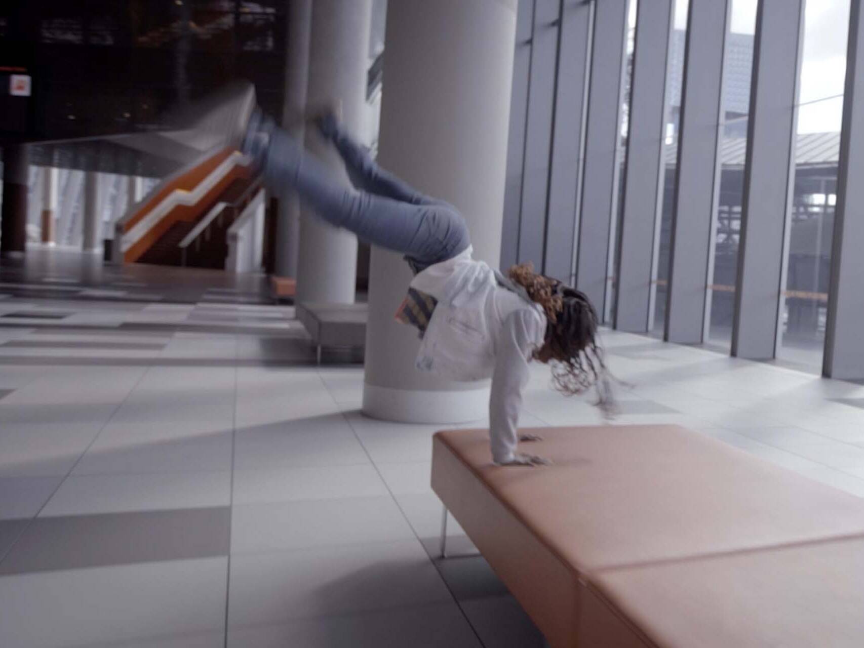 Young female dancer cartwheeling through the Melbourne Convention Centre