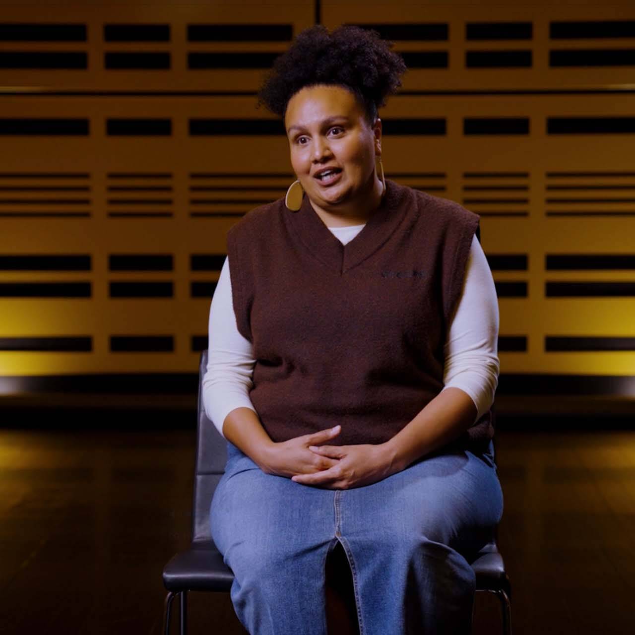 Woman sat on chair speaking to camera