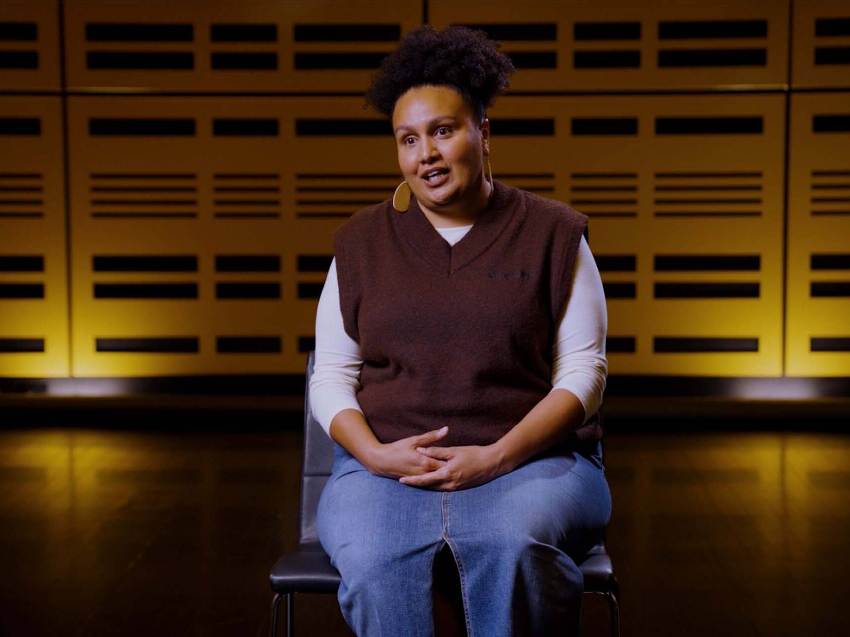 Woman sat on chair speaking to camera