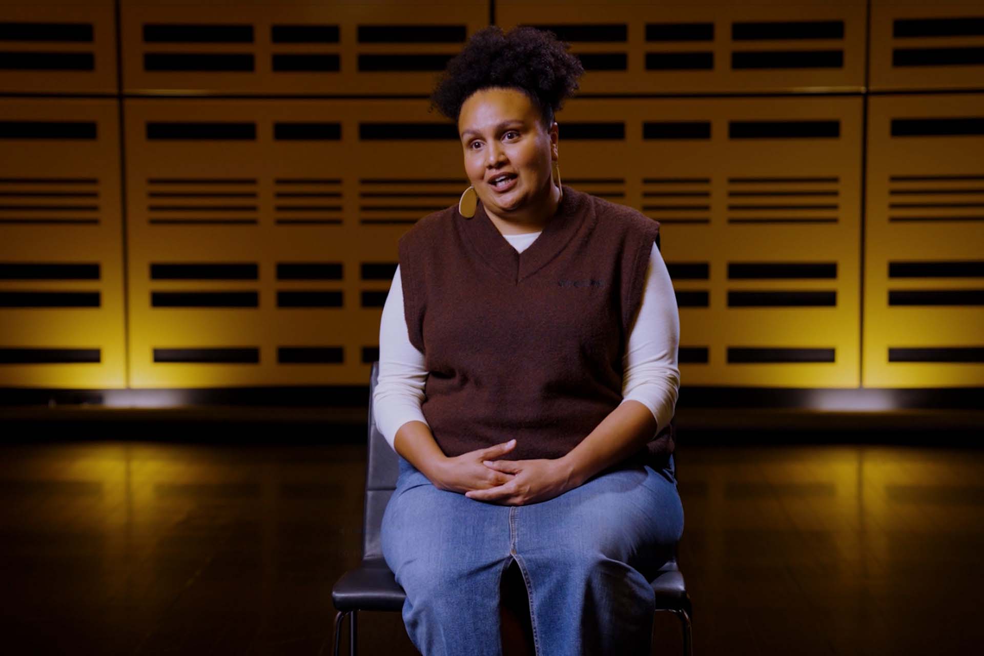 Woman sat on chair speaking to camera